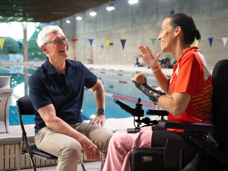 Apple CEO Tim Cook sat on a chair with a swimming pool in the background talking to Professional Paralympic Swimmer; Teresa Perales uses the Apple Watch for her insane training.